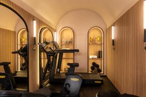 a gym with a mirror and some exercise bikes at Hôtel le 6 Tiquetonne in Paris