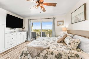 a bedroom with a bed and a flat screen tv at Oceanfront St Helena Island Condo w/ Beach Access! in Oceanmarsh Subdivision +37 photos