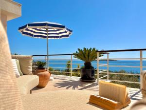 a patio with an umbrella and a view of the ocean at Villa Tempera in Vis