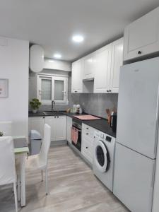 a kitchen with white cabinets and a white refrigerator at Apartamento Grao in Gandía