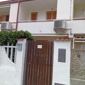 a house with a wooden gate and two air conditioners at Casa Torre in Fiumefreddo Bruzio