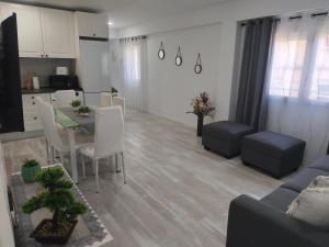 a kitchen and a living room with a table and chairs at Apartamento Grao in Gandía +6 photos