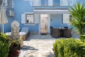 a patio with a table and chairs and a blue wall at Villa Bella Vista - apartments in Labin +37 photos