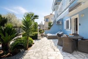 a patio with a table and chairs on a blue building at Villa Bella Vista - apartments in Labin