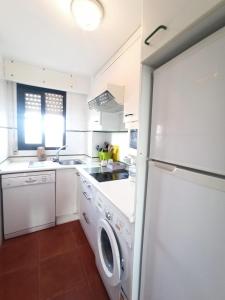 a kitchen with a white refrigerator and a dishwasher at ALCAUDÓN By SIT ISLA CANELA -REF 282- in Ayamonte