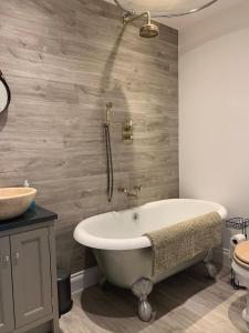 a bathroom with a tub and a sink at 3 or 4 Bed 2 Bath Cosy Rural Barn Conversion-Parking in Beoley