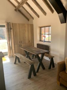 a dining room with a wooden table and benches at 3 or 4 Bed 2 Bath Cosy Rural Barn Conversion-Parking in Beoley +25 photos
