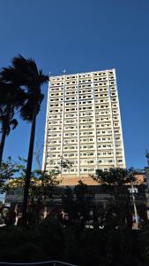 a large white building with a palm tree in front of it at Kim's Cozy Place - Parthenon Residences in Cebu City