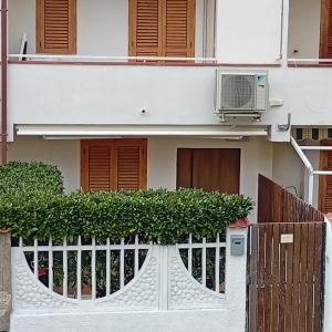 a white house with a fence and a building at Casa Torre in Fiumefreddo Bruzio