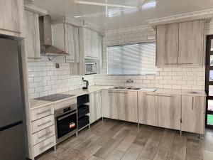 a kitchen with wooden cabinets and a sink and a stove at Yandheya Guest House in Calcutta
