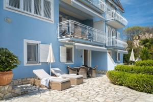 a patio in front of a blue building at Villa Bella Vista - apartments in Labin