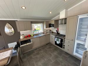 a kitchen with a sink and a stove top oven at Luxury Lakeside Lodge L2 with Hot tub situated at Tattershall Lakes Country Park in Tattershall