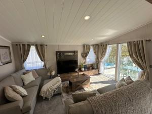a living room with a couch and a flat screen tv at Luxury Lakeside Lodge L2 with Hot tub situated at Tattershall Lakes Country Park in Tattershall