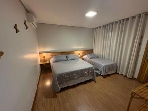 a bedroom with two beds and a window at Pousada Vento Sul in Chapada dos Guimarães