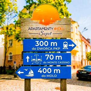a street sign with several signs on it at Apartamenty4you - Apartamenty Atlantic in Sopot
