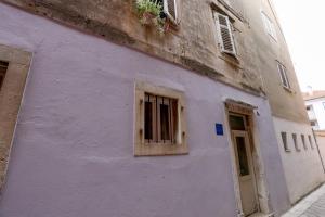 a purple building with a window and a door at Boutique Suite 02 Chic in Zadar