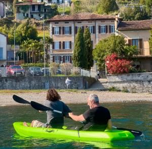 two people sitting on a kayak in the water at Immobillario - Domus Palmae in Domaso