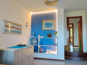 a room with a blue wall with a counter and shelves at Villa Gino in Stintino
