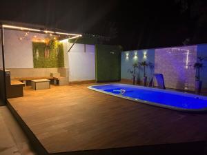 a large swimming pool in a room with a table and a bench at Onde o verão nunca termina! in Peruíbe