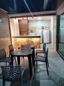 a dining room with a table and chairs and a kitchen at Onde o verão nunca termina! in Peruíbe