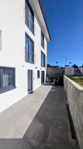 a courtyard of a white building with a stone wall at Gemütliche Wohnung mit Terrasse nahe Würth in Künzelsau