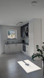 a white kitchen with white cabinets and a window at Gemütliche Wohnung mit Terrasse nahe Würth in Künzelsau