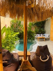 a resort with a swimming pool and an umbrella at Villa Naka - Gili Trawangan - Traditional Villa & Private pool in Gili Trawangan +94 photos