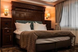 a bedroom with a large bed with a wooden headboard at Pensiunea Eden in Târgu Neamț +290 photos