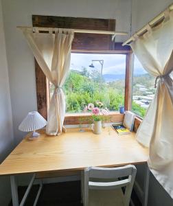 a wooden desk with a window with a view at Hiên nhà Đà Lạt in Ấp Kim Thạch