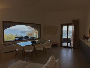 a living room with a table and chairs and a large window at Villa Allegra Luxury Holiday House in Salò