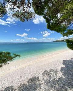 a view of a white beach with the ocean at Villa ARINA - Apartments 20 m from Beach, Tucepi in Tučepi