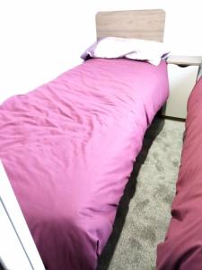 a bed with purple comforter in a bedroom at Nutmeg golden sands haven in Mablethorpe