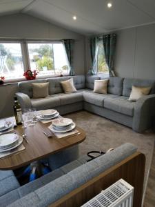 a living room with a couch and a table at Nutmeg golden sands haven in Mablethorpe