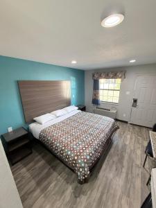 a bedroom with a large bed with a wooden floor at Relax Inn Bryan College Station in Bryan +28 photos
