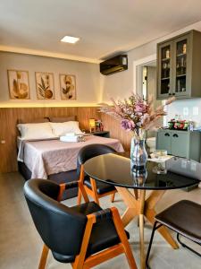 a bedroom with a bed and a table and chairs at 1106 - Vila Germânica in Blumenau