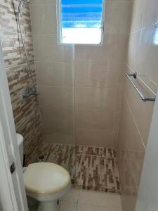 ein Badezimmer mit Toilette und Dusche mit Fenster in der Unterkunft La marquesa in Los Paredones