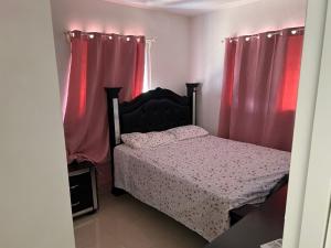 ein Schlafzimmer mit einem Bett und roten Vorhängen in der Unterkunft La marquesa in Los Paredones
