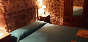 a bedroom with a bed with a blue comforter at Cabañas Altos del Velazco in La Rioja