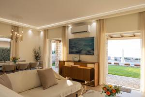 a living room with a white couch and a table at Seafront Villa Ciel with Private Pool in Nafpaktos in Nafpaktos
