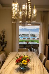 a dining room with a table with a vase of flowers at Seafront Villa Ciel with Private Pool in Nafpaktos in Nafpaktos