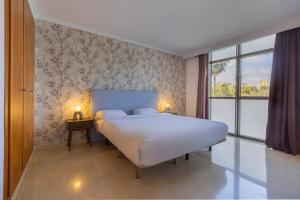 a bedroom with a large white bed and a window at BHost - Bellagio II in Benalmádena +45 photos