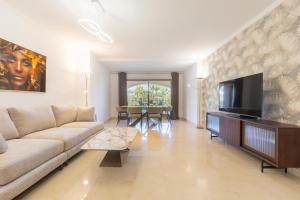 a living room with a couch and a flat screen tv at BHost - Bellagio II in Benalmádena
