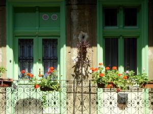 dom z kwiatami na płocie i oknem w obiekcie Miniapartman Budapest w Budapeszcie