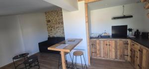 a kitchen with a wooden table and some stools at La Maison de Pandora in Maulévrier
