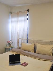 a laptop computer sitting on top of a bed at Hiên nhà Đà Lạt in Ấp Kim Thạch