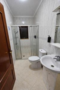 a bathroom with a shower and a toilet and a sink at Casa da Charrua in São Teotónio +13 photos