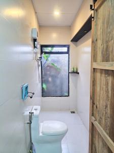 a small bathroom with a toilet and a window at Hiên nhà Đà Lạt in Ấp Kim Thạch +34 photos