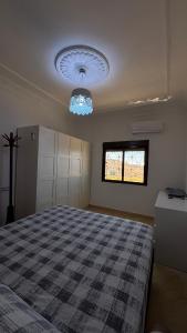 a bedroom with a bed and a chandelier at Maison campagne piscine ksar in Ksar es Sghir +24 photos