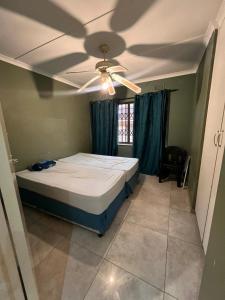 a bedroom with a bed and a ceiling fan at Smith House in Durban