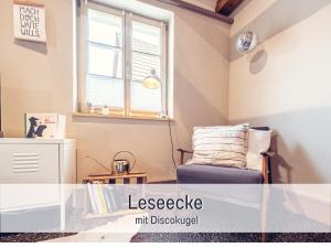a living room with a chair and a window at Molly Moll - Mini Ferienhaus in Kyritz, einer charmanten Stadt im Herzen von Brandenburg in Kyritz